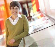 Professor Ann Muggeridge leaning on rock collection display
