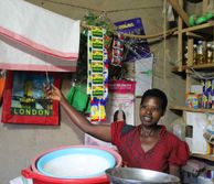 African woman in a shop in Rwanda clicking a power switch