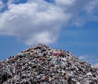 mountain of rubbish waste against a blue sky