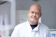 Man wearing glasses and a lab coat