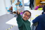 A child participates in the Saturday Science Club and shows a model aeroplane she has made