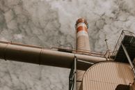 A view of a factory tower against a cloudy sky