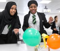 Two school girls taking part in an engagement activity