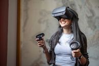 A student using a VR headset while smiling