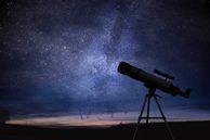 Telescope with starry sky behind it