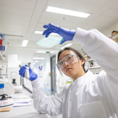 Student with blue gloves in a lab