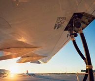 Wing of a plane being refuelled in the sunset