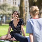 students sitting smiling on the grass