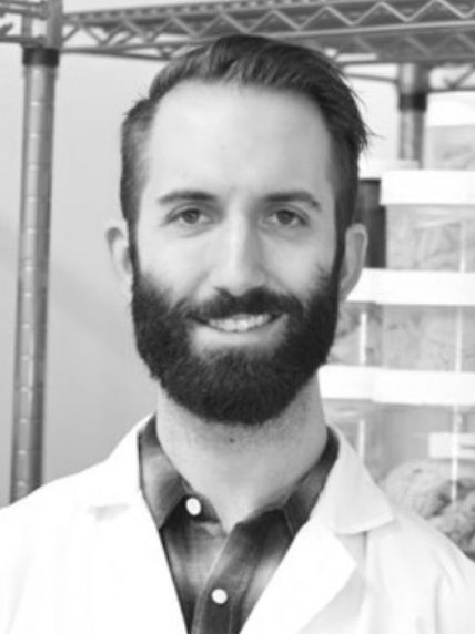 black and white headshot of man smiling