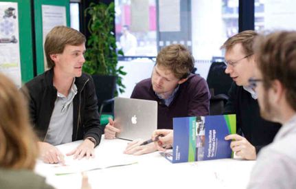 Academics on a table with laptop and publications