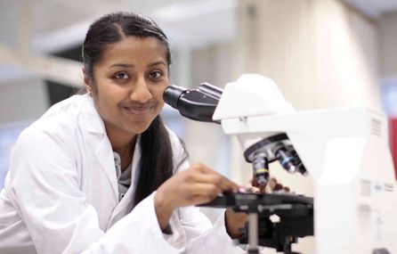 Woman with microscope in laboratory