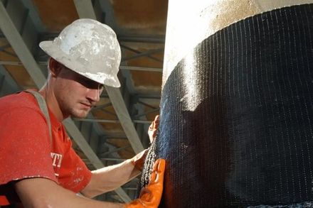Figure shows a technician is repairing a concrete column by wrapping it with carbon fibre fabrics.