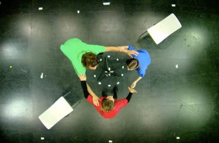 Aerial view of three people linking arms taking part in an immersive performance