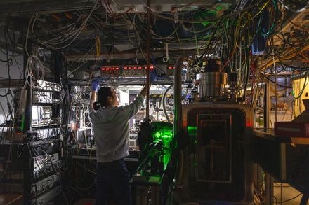 A researcher adjusts a power supply on the CaF experiment in the Centre for Cold Matter