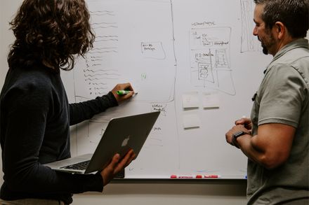 Team members annotating a wipeboard