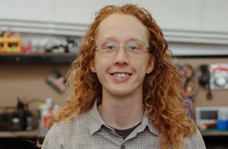 Headshot of Iain Purves with a workshop in the background