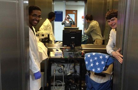 A photo os us crammed in a lift with the experiment and a child in a buggy