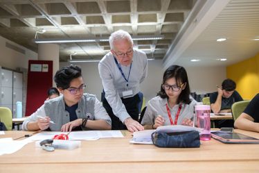 A teacher helps to student in an academic English class with her work