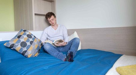 Student reading on bed