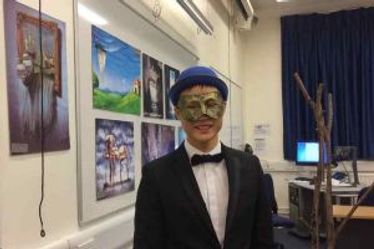 A student in a mask and hat and bow tie in a classroom