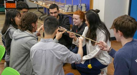 A group of male and female students completing a team building activity together