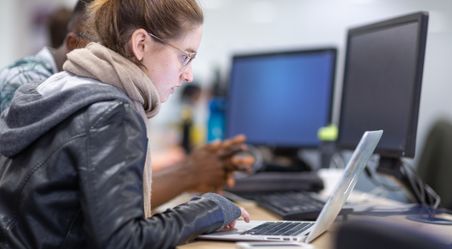 A student working on a laptop in a computer lab 