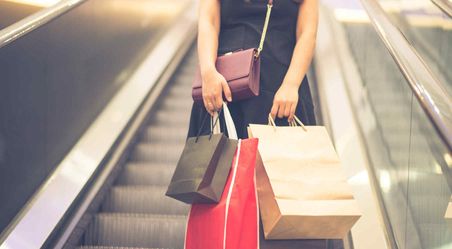 Lady on escalator holding shopping bag