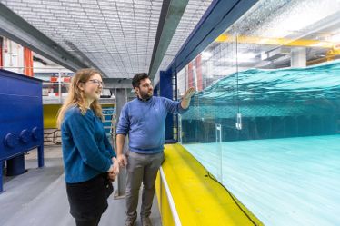 Two researchers looking at a hydrodynamics tank