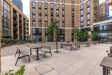 Courtyard surrounded by buildings with seating and trees