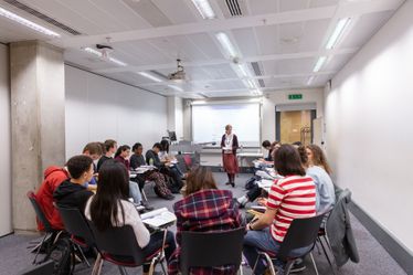 People sat on chairs in a circle in a classroom