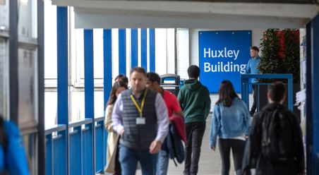 stuents walking along the walkway from the huxley building