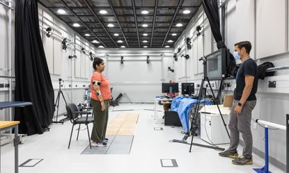A woman being monitored looking at a screen, with a man observing