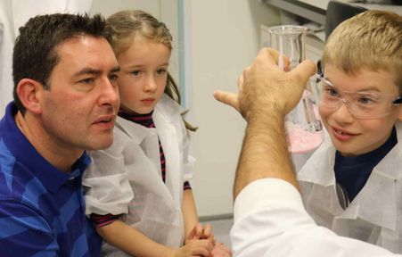 Children and dad look at flask