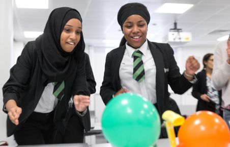 School children working in a lab experimenting with balloons