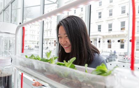 Student smiling with growing plants in the Hackspace