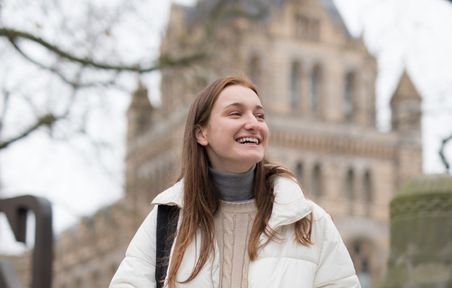 Student smiling in front of the Natural History Museum