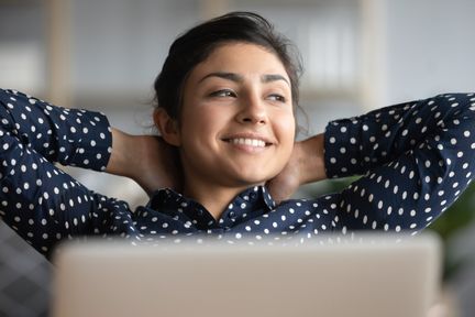 Young woman at dsk looking happy