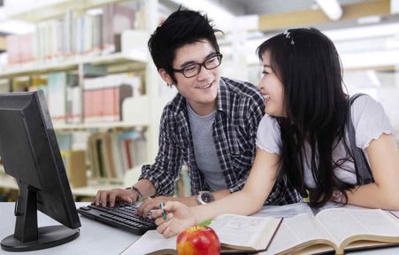 Students using a laptop in the Library