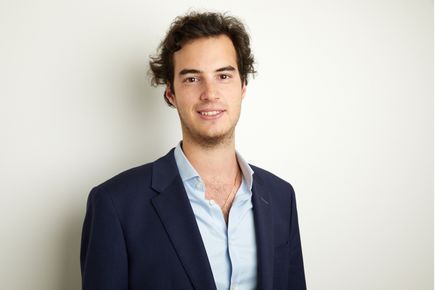 Michael Moses smiles at the camera, against a white background