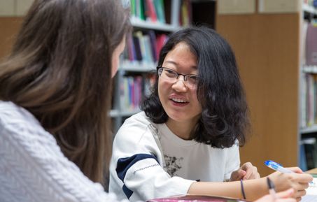 student smiling in library.