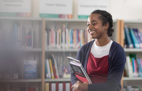 Student standing with books in hands