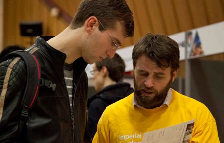 A prospective postgraduate talks to a representative at a college open day