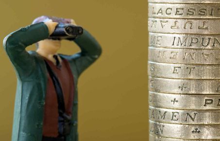 man fugurine looking at coins