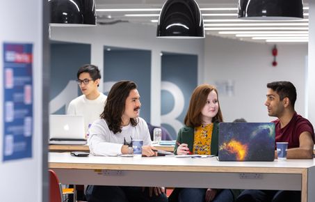 Student sitting at desk chatting to each other