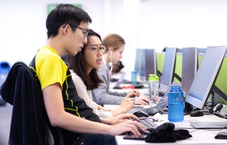 Students on a computer desk in library