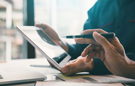 hands holding tablet computer and pen