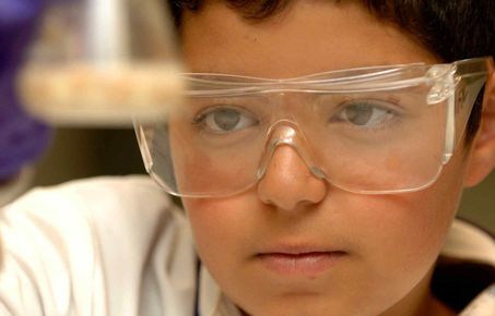 Boy looks at conical flask