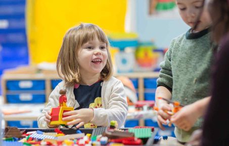 young girl plays with duplo