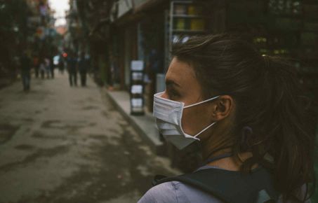 woman wearing a air filter mask in a city street