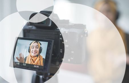 A young woman captures a image of herself presenting on camera